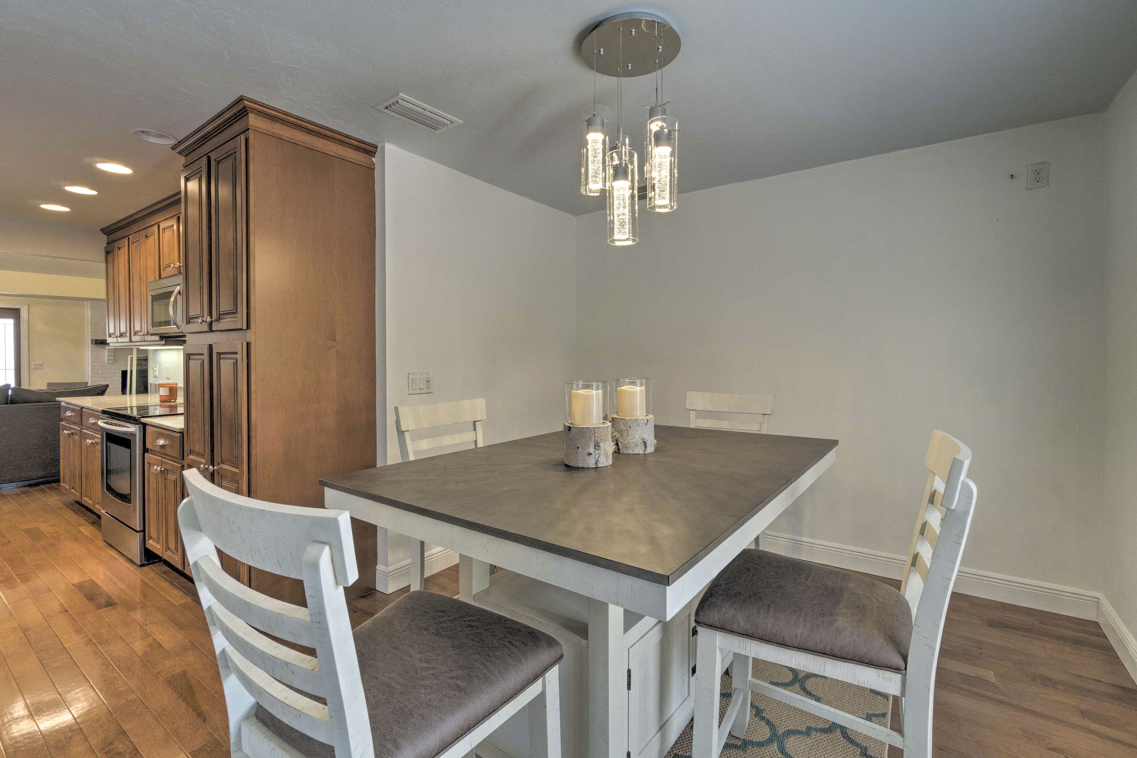 Una cocina moderna con armarios de madera, electrodomésticos de acero inoxidable y un comedor con mesa y sillas.