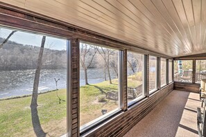 A room with large windows overlooking a river, a wooden ceiling, and a seating area with a view of the outdoors. - White River Fishing Escape w/ Deck & Patio! (Cotter)