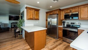 Una cocina moderna con armarios de madera, un refrigerador de acero inoxidable y un horno empotrado.