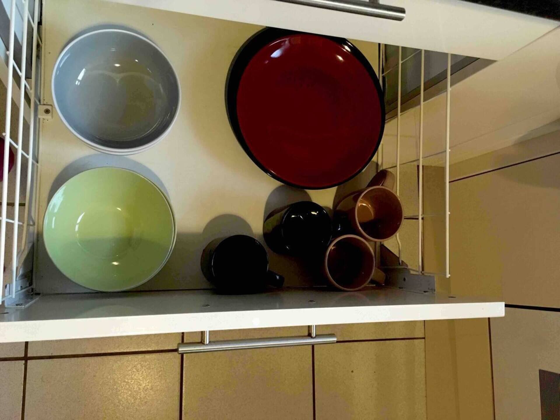 Un meuble de cuisine contenant différents plats et ustensiles.