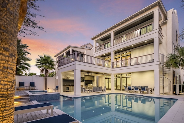 Um edifício moderno de vários andares com piscina, área de estar ao ar livre e um terraço coberto.