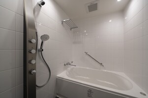 A modern bathroom with a bathtub, a shower with a handheld showerhead, and a wall-mounted towel rack.