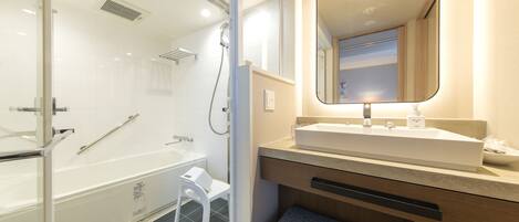A modern bathroom with a glass-enclosed shower, a white sink, and a mirror above it.