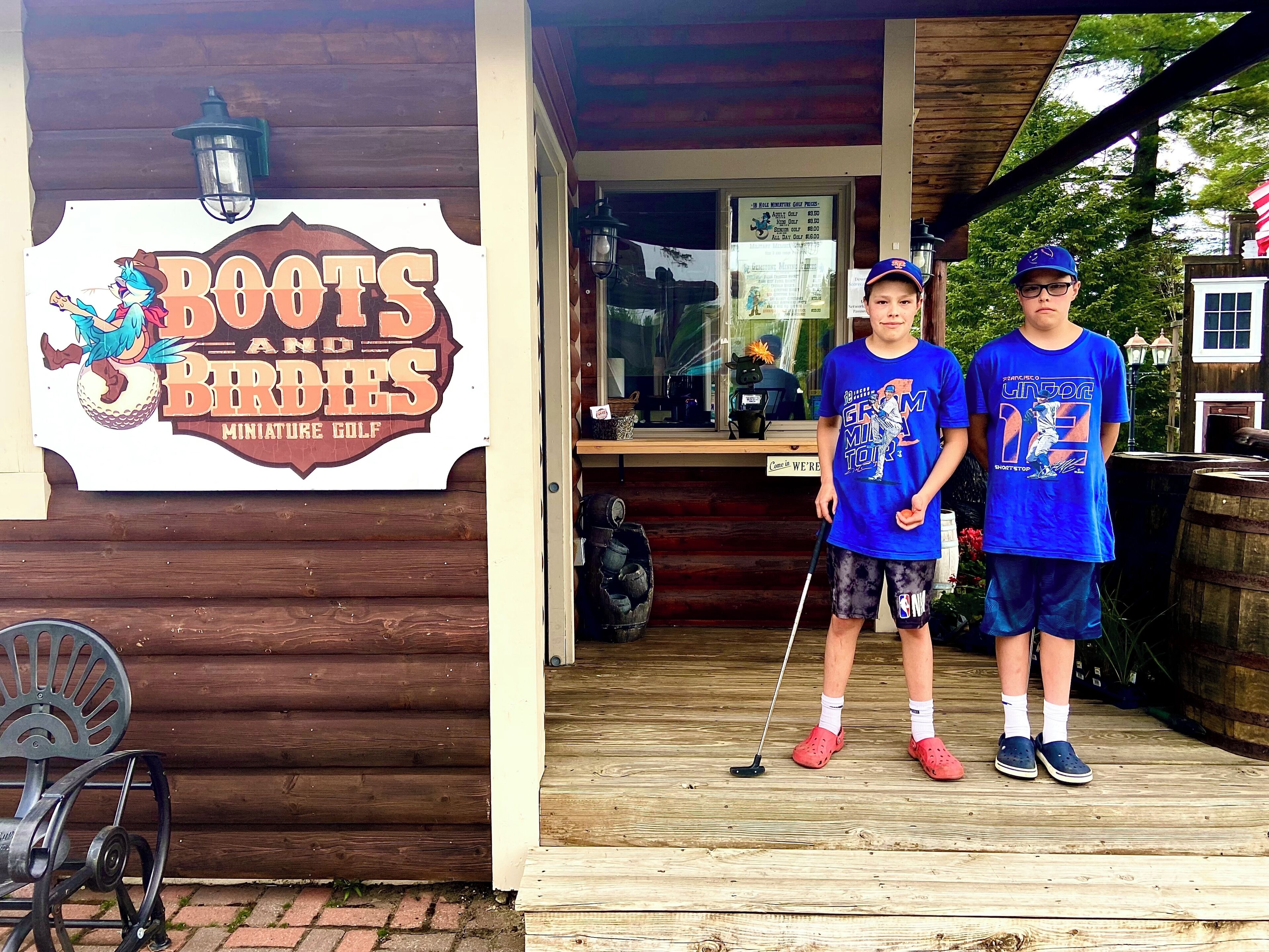 A sign for 'Boots and Birds Miniature Golf' with two people standing in front.