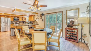 A spacious kitchen with wooden cabinets, a central island, and a dining area with a round table and chairs. - Near Hiking Trails: Cabin w/ Deck in Pioneer! (Pioneer)