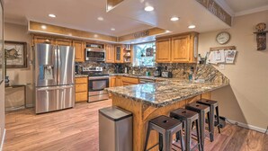 A modern kitchen with stainless steel appliances, wooden cabinets, and a granite countertop. - Near Hiking Trails: Cabin w/ Deck in Pioneer! (Pioneer)