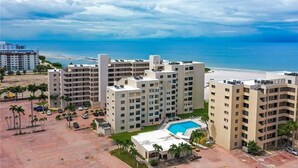 A hotel complex with multiple buildings, a swimming pool, and a beach view. - Coastal Escape ● Steps to Beach ● Sunset Views (Fort Myers Beach)