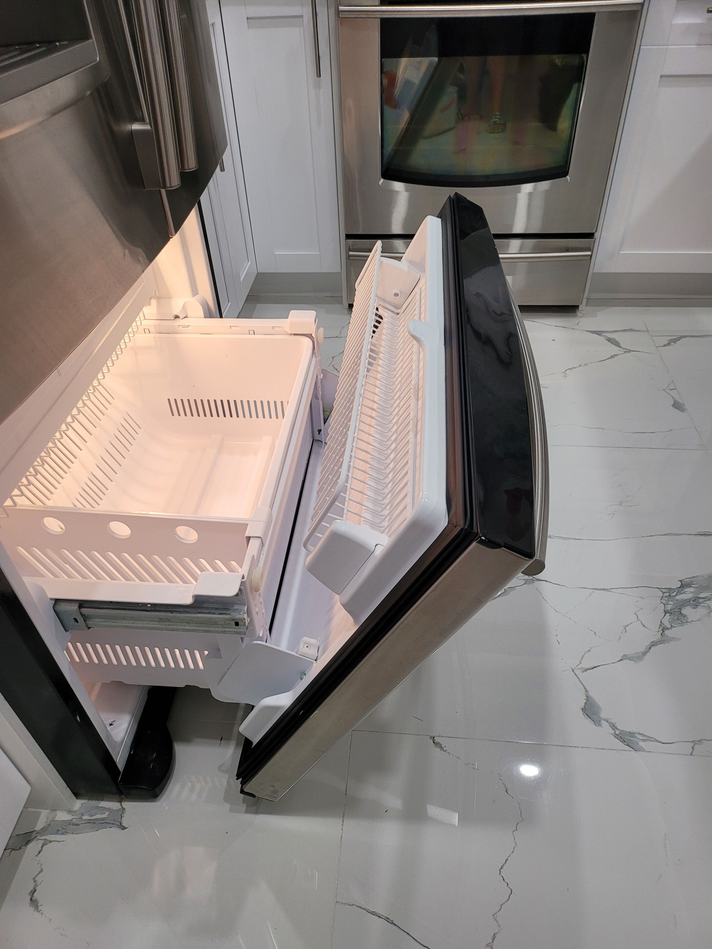 A kitchen with a dishwasher, oven, and tiled floor.