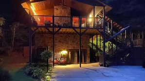 A two-story building with a stone facade, a balcony on the upper level, and a car parked in front. - Rally Point, Creekside retreat in the Smokies` (Sevierville)