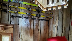 Una habitación rústica de madera con literas, una escalera de madera y una ventana con vistas.
