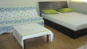 A room with a sofa, a bed, and a small table. - Room-t8 Guest House Don Mueang Challenge (Pak Kret)