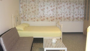A room with a bed, a sofa, and a small table. - Room-chan Kim Don Mueang Guest House, lo (Pak Kret)
