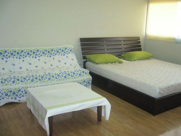 A room with a sofa, a bed, and a small table. - Room-thailand Taxi&apartment Hostel, air (Pak Kret)