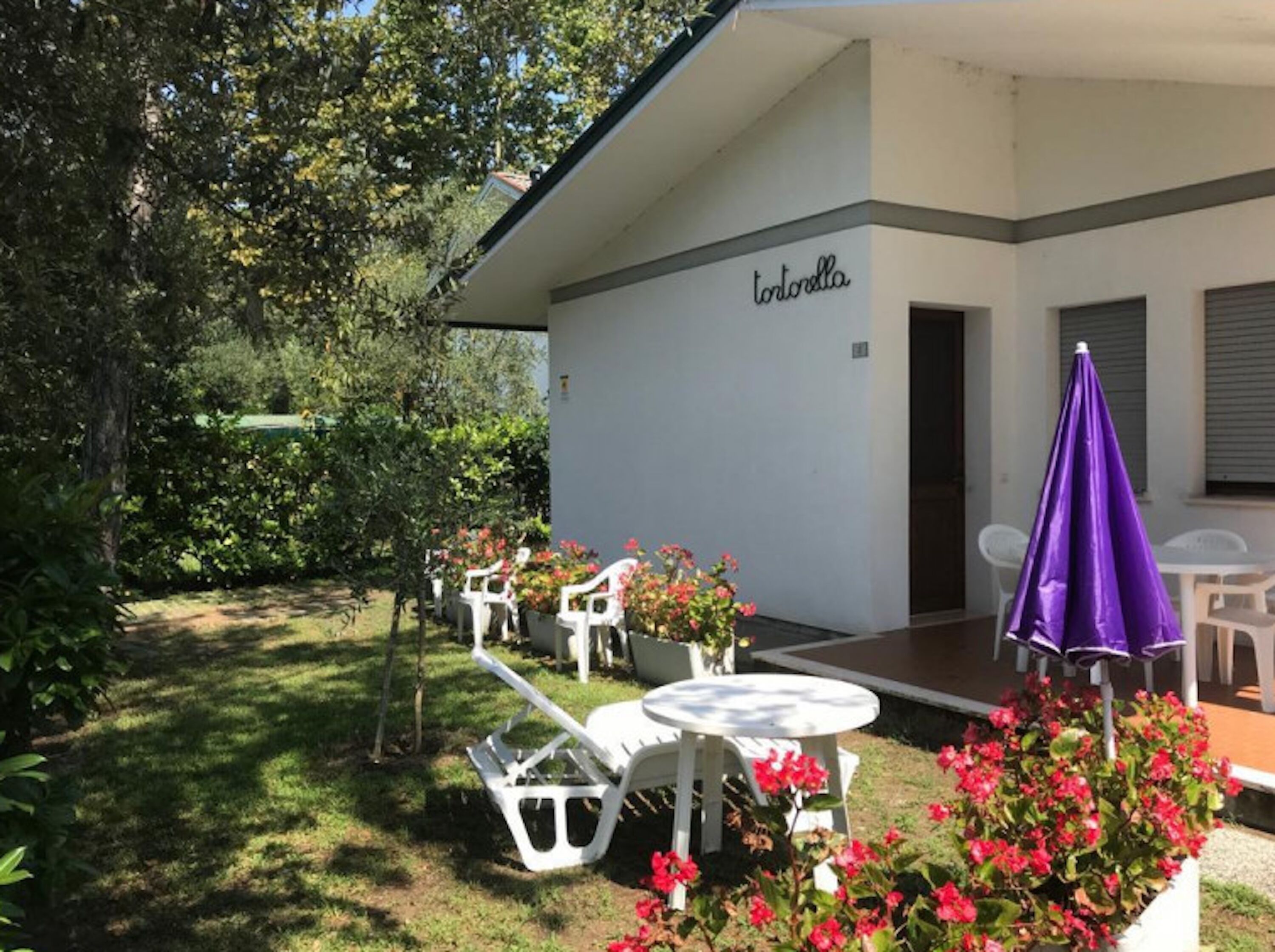 Un bâtiment sur lequel on peut lire l’inscription « tortorilla », avec une terrasse comprenant des chaises et des tables blanches.