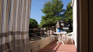 Un balcon avec un sol à rayures, une table et des chaises.