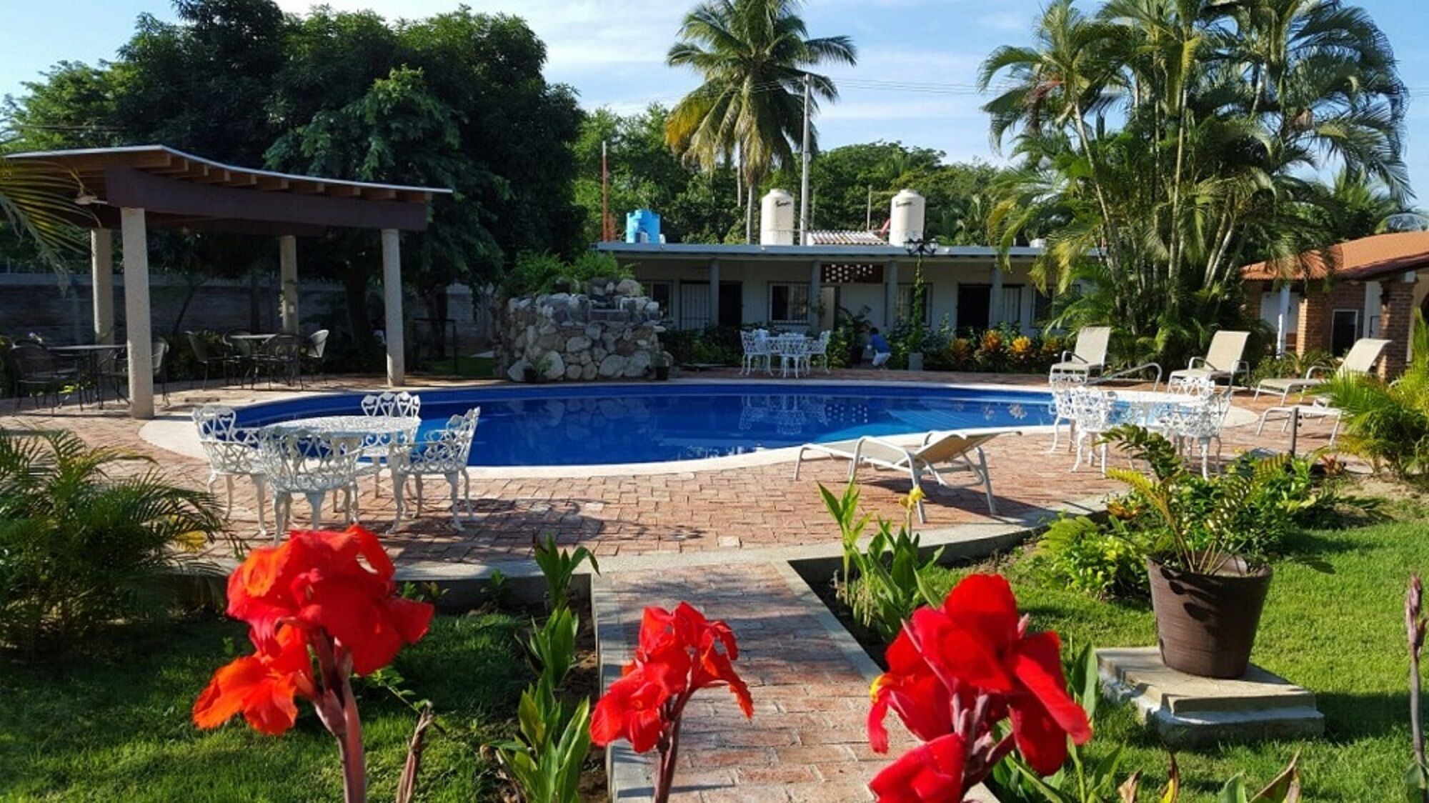 A swimming pool with lounge chairs and a covered patio area.