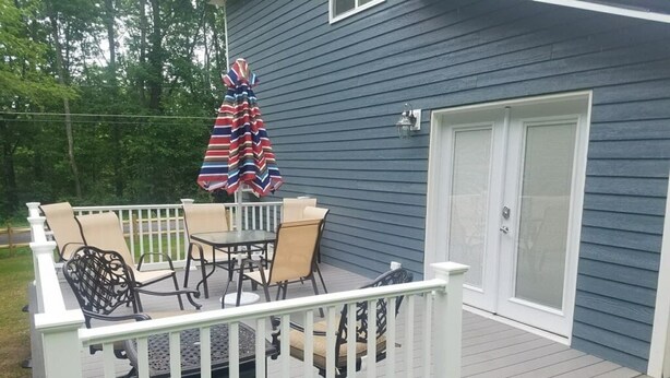 Une terrasse dotée de mobilier d’extérieur et d’une table abritée.