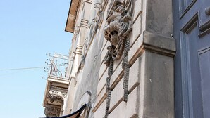A building facade with ornate stone carvings and a balcony with a wrought iron railing. - Palazzo Nicastro Guest House Blue (Avola)