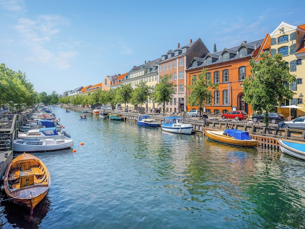 Stroll along the serene canal, surrounded by historic European-style buildings and picturesque boats.