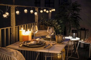 An outdoor dining area with candles, wine glasses, and a table set for two. - Leaves 2- Chic Apt for 8 Persons in Central Copenhagen (Copenhagen)