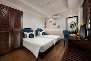 A hotel room with two beds, a desk, a chair, a mirror, and a wardrobe. - Maya Boutique Hotel and Spa (Hanoi)