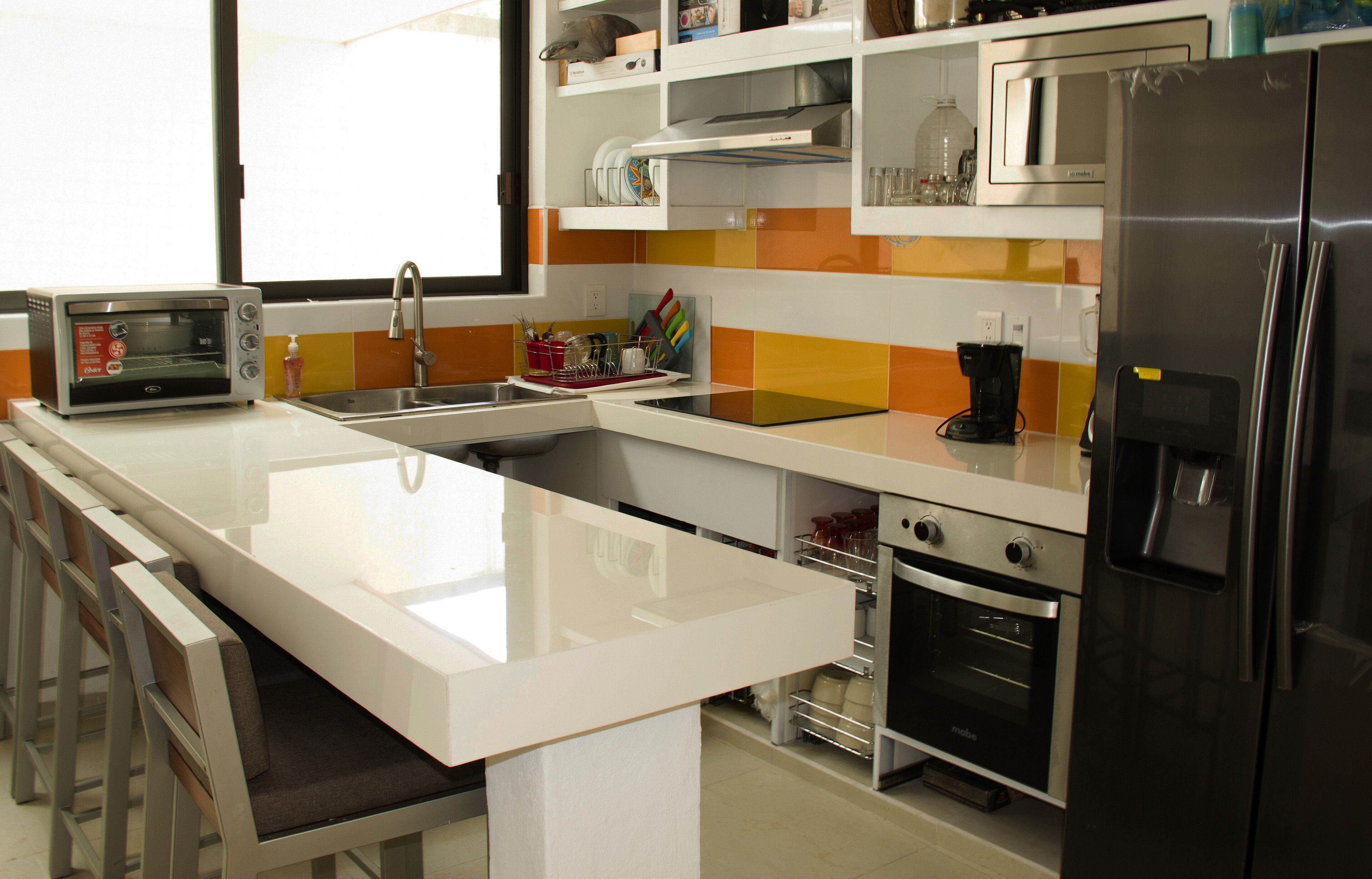A modern kitchen with a white countertop, stainless steel appliances, and a built-in oven.