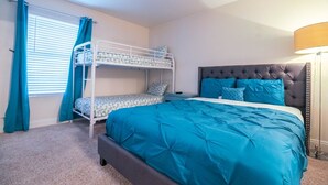 Een slaapkamer met een stapelbed, een eenpersoonsbed en een nachtkastje.