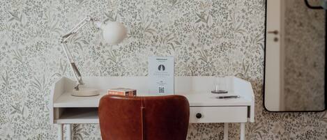 A desk with a white lamp, a brown chair, and a sign with a QR code.