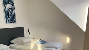 A modern bedroom with two beds, a large window, and a view of the sky. - Glück Auf Appartement Lösortstraße (Duisburg)