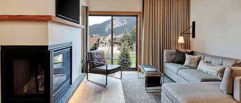 Una sala de estar moderna con chimenea, un sofá, una mesa de centro y un televisor.