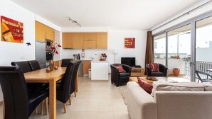Un apartamento moderno con comedor, cocina, sala de estar y un balcón con vistas.