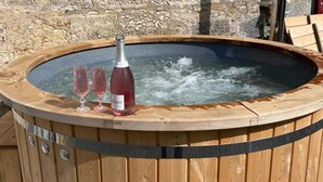 A wooden hot tub with a bottle of champagne and two glasses. - Inviting 2-bed Barn With hot tub Near Muirkirk (Cumnock)