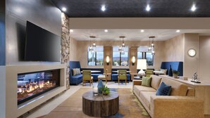 A modern living room with a fireplace, comfortable seating, and large windows. - Residence Inn by Marriott Sedona (Sedona)