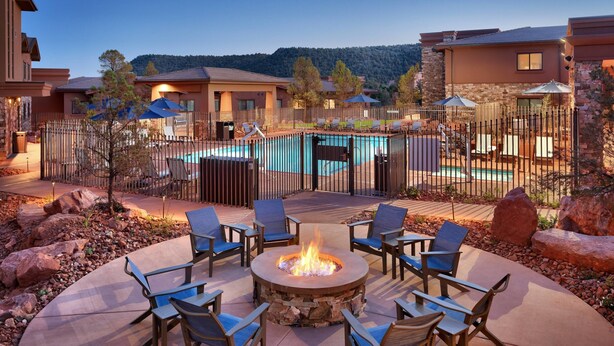 A patio area with a fire pit, outdoor seating, and a swimming pool. - Residence Inn by Marriott Sedona (Sedona)