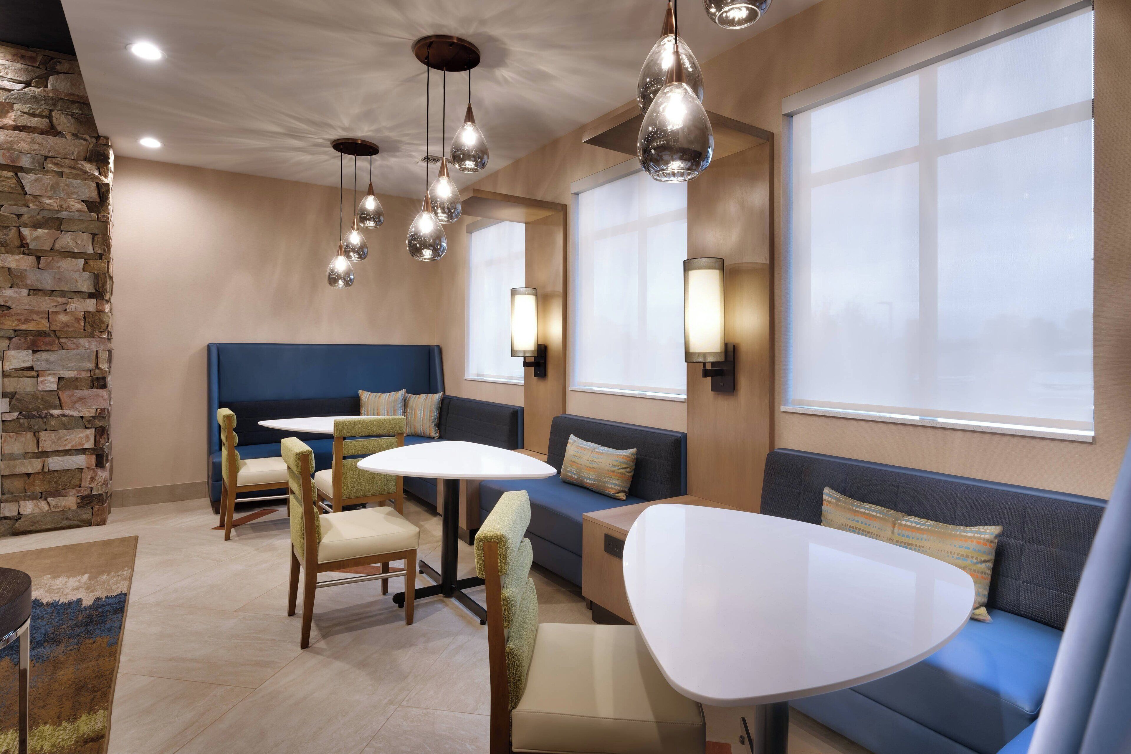 A modern interior with a stone accent wall, a blue sofa, and a round table.