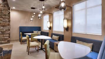 A modern interior with a stone accent wall, a blue sofa, and a round table.