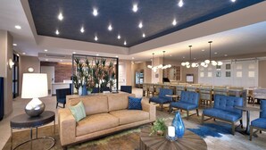 A modern hotel lobby with a sofa, chairs, a coffee table, and a dining area. - Residence Inn by Marriott Sedona (Sedona)