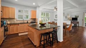 Une cuisine moderne avec des meubles en bois, un îlot central et un coin repas avec des chaises.