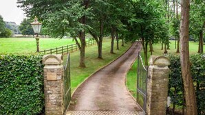 A paved pathway leading through a park with a metal gate and stone pillars. - Stunning Country Farm House between Bristol & Bath (Bristol)