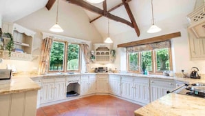 A spacious kitchen with white cabinetry, large windows, and exposed wooden beams. - Stunning Country Farm House between Bristol & Bath (Bristol)