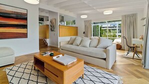 A modern living room with a sofa, coffee table, and artwork on the wall.
