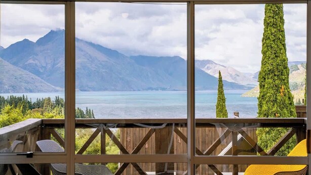 A balcony with a view of mountains and a lake.