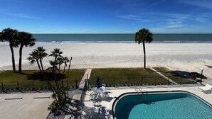 Un espace piscine offrant une vue sur la plage et l’océan.