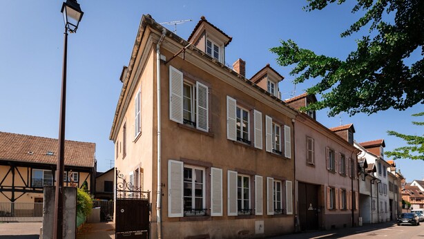 A traditional European building with multiple windows and a door, likely a hotel or residential building.