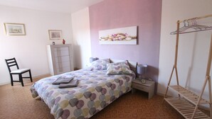 A bedroom with a bed, nightstands, a chair, a wardrobe, and a wall-mounted drying rack. - Colmar City Center - Appartement SCHNAPSALA - BookingAlsace (Colmar)