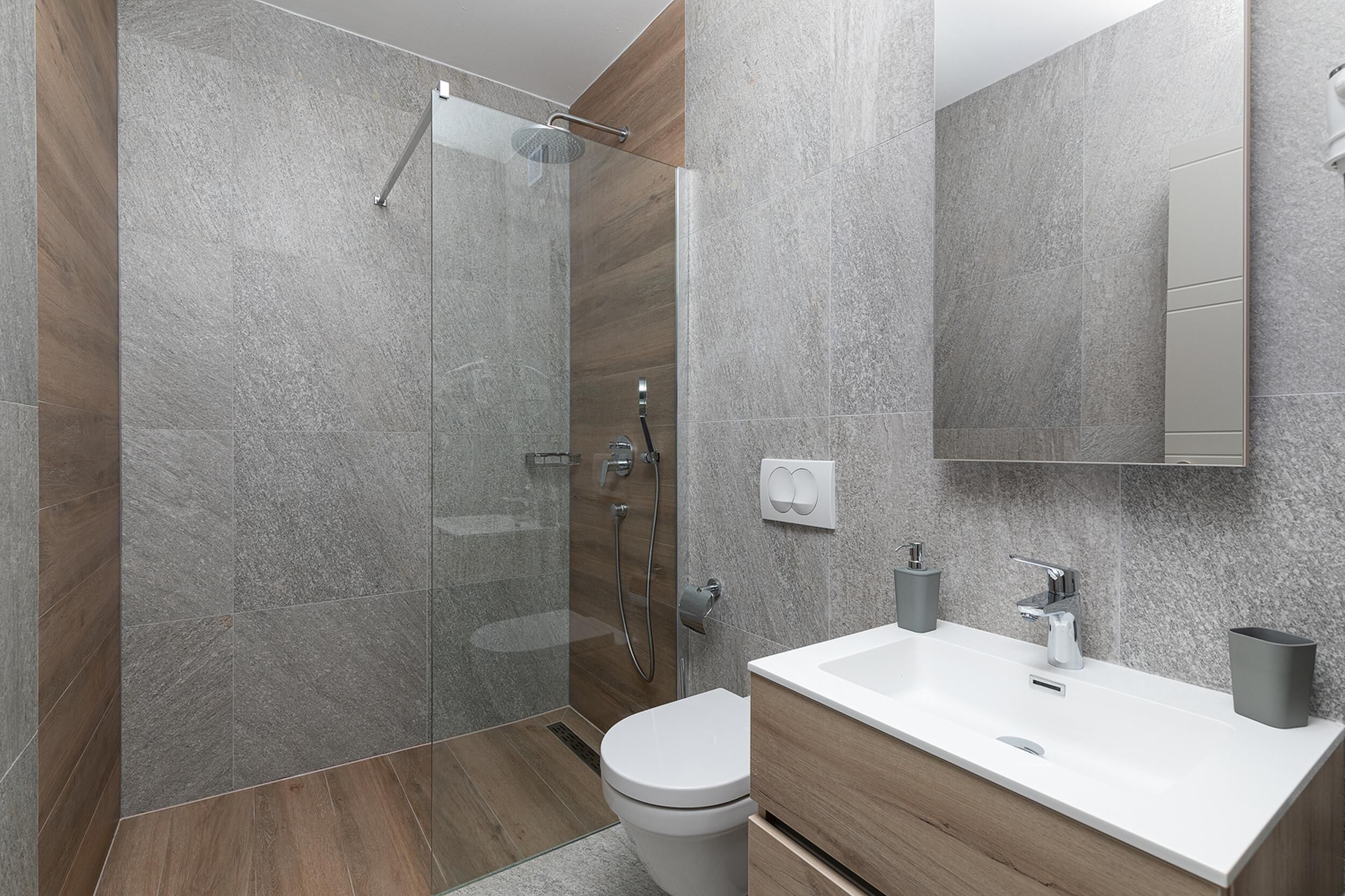 Un baño moderno con ducha, inodoro y lavamanos.