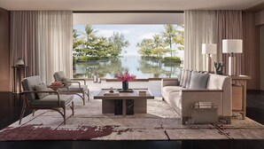 A modern living room with a view of a lake, featuring a sofa, chairs, a coffee table, and lamps. - Regent Phu Quoc (Phu Quoc)