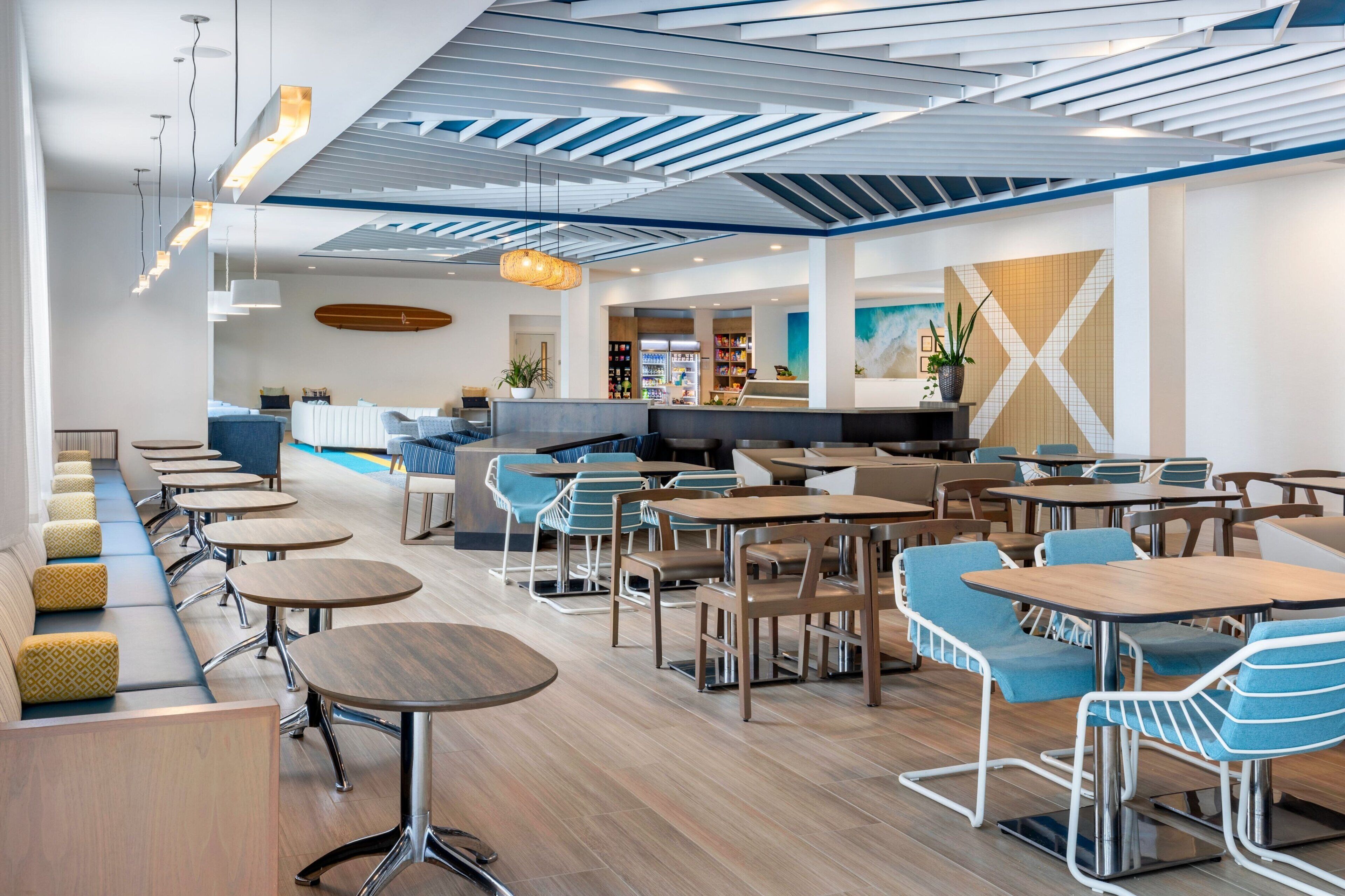 A modern indoor space with seating areas, tables, and a counter.