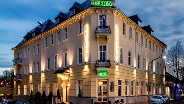 Um hotel chamado "EUROPA", com café no andar térreo, várias varandas e estilo arquitetônico clássico.