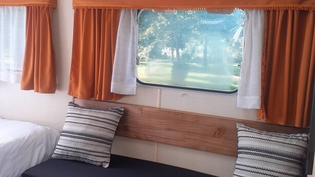 A room with two beds, a window with curtains, and a view of trees. - -- Diligence -- (Aire-sur-l'Adour)